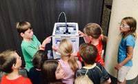 kids running a 3d printer